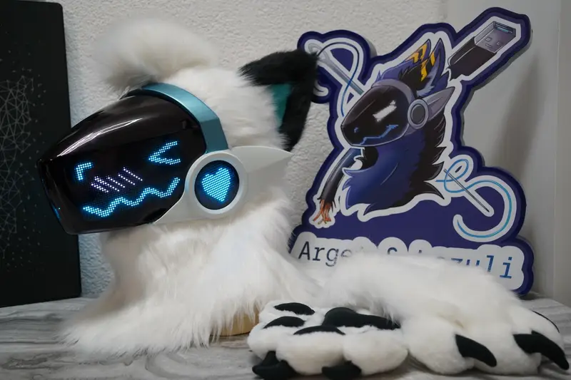 White Protogen head with black ears, a cyan LED face and a heart on the ear light, next to its white hand paws with black claws
