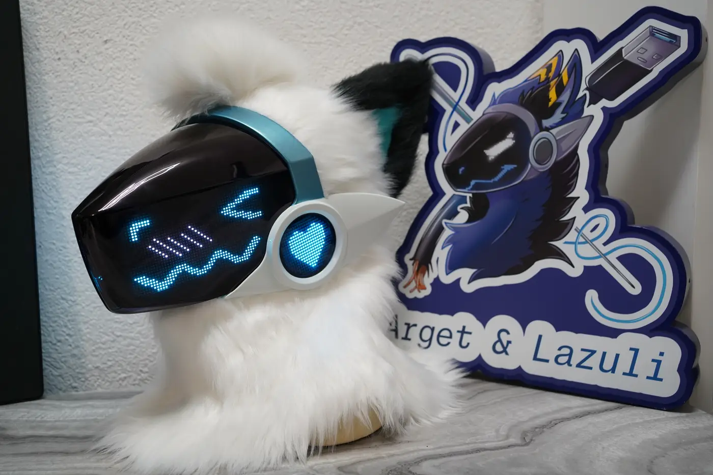 White Protogen head with a teal shell, cyan pixel eyes, blush lines and a zigzag mouth on the black LED visor