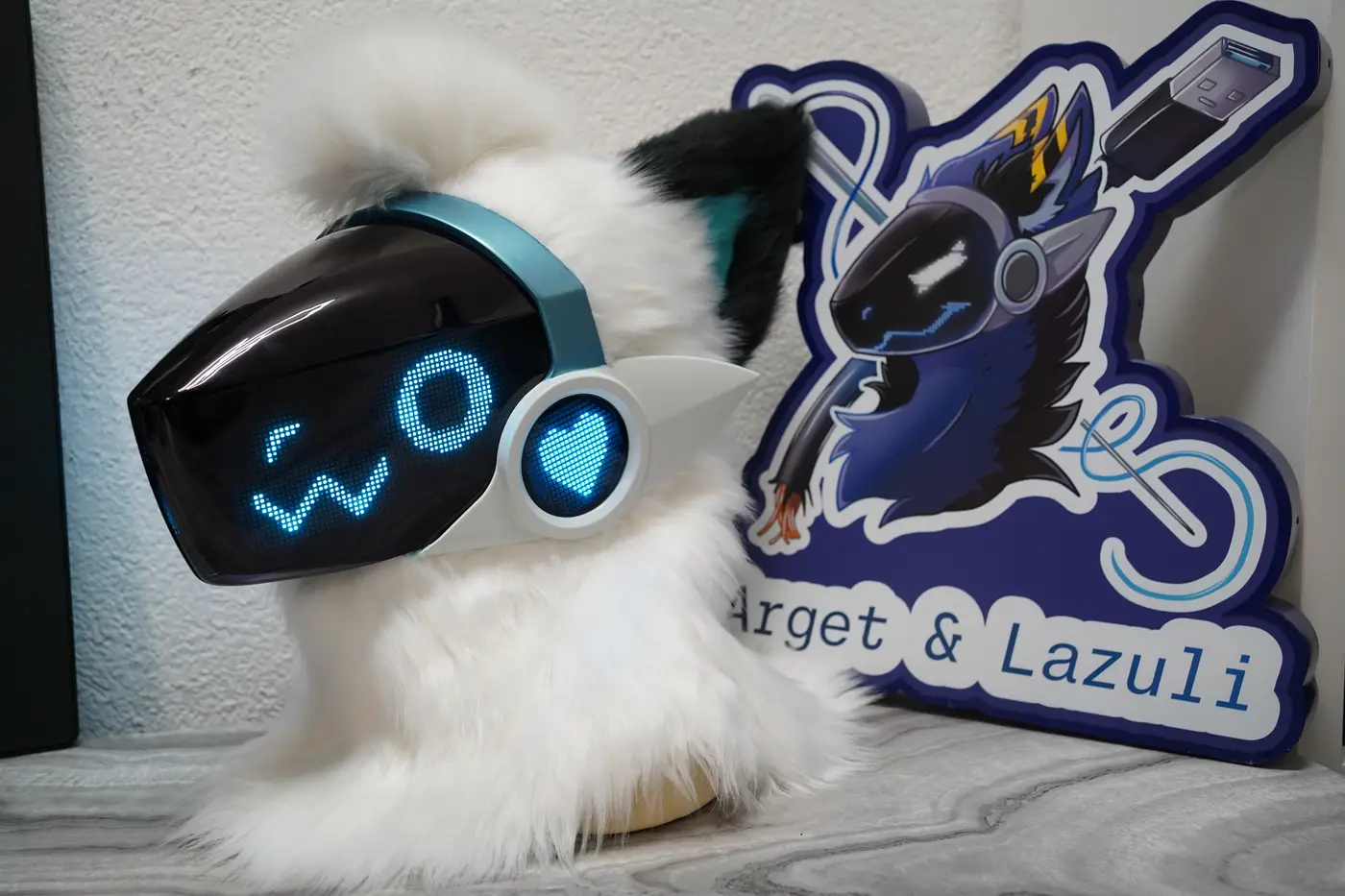 White Protogen head with a winking cyan eye, a round pixel eye and a small w shaped mouth on the black LED visor