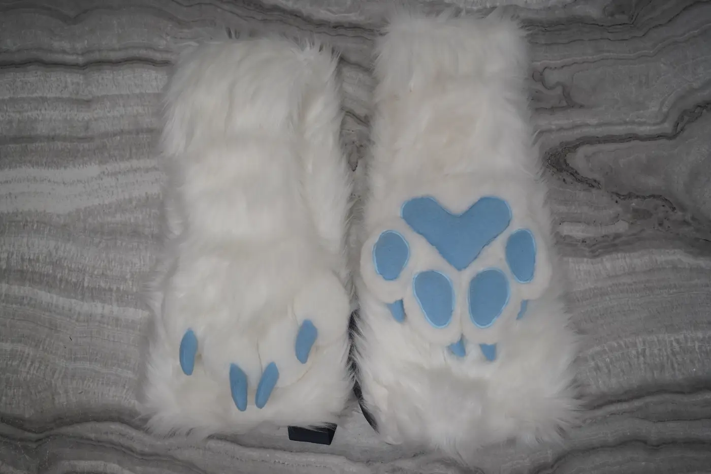 White puffy Protogen hand paws with light blue claws and a heart shaped palm pad, seen from the back and the palm