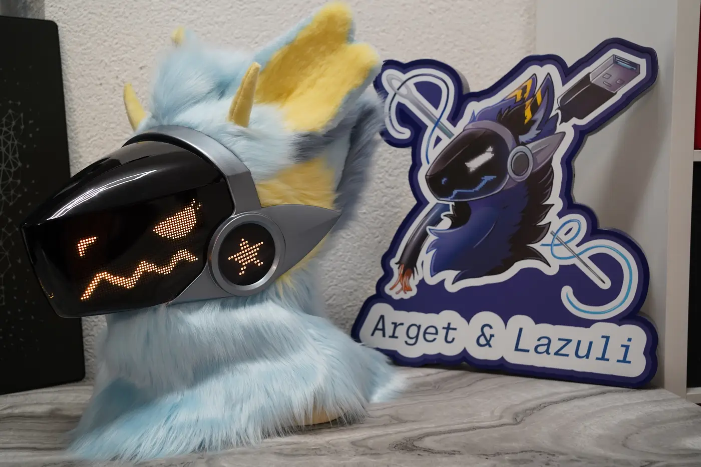 Light blue Protogen head with an angry yellow pixel expression on the LED visor