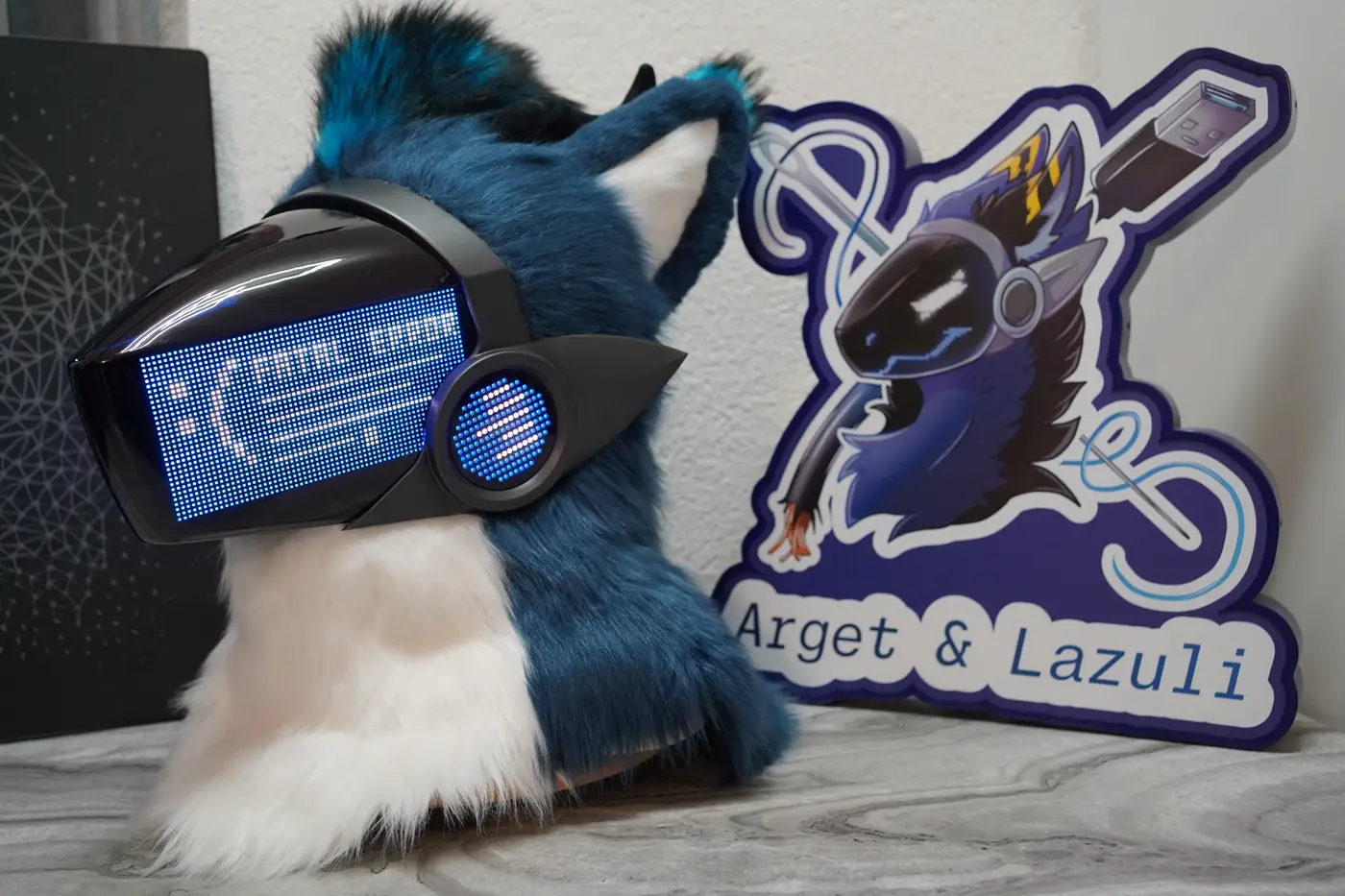 Blue Protogen head with colour game icons and a status bar on the LED visor