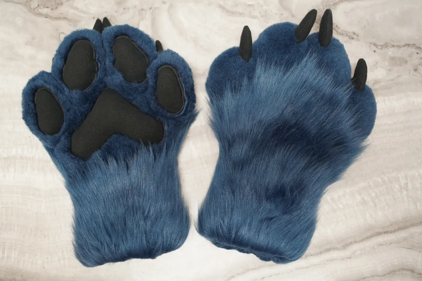 Blue Protogen hand paws with black pads and claws